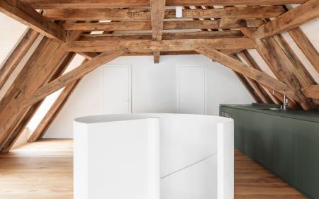 Moderner weißer freistehender Treppe unter sichtbaren Holzbalken in einem Dachgeschoss mit Eiche Holzboden.