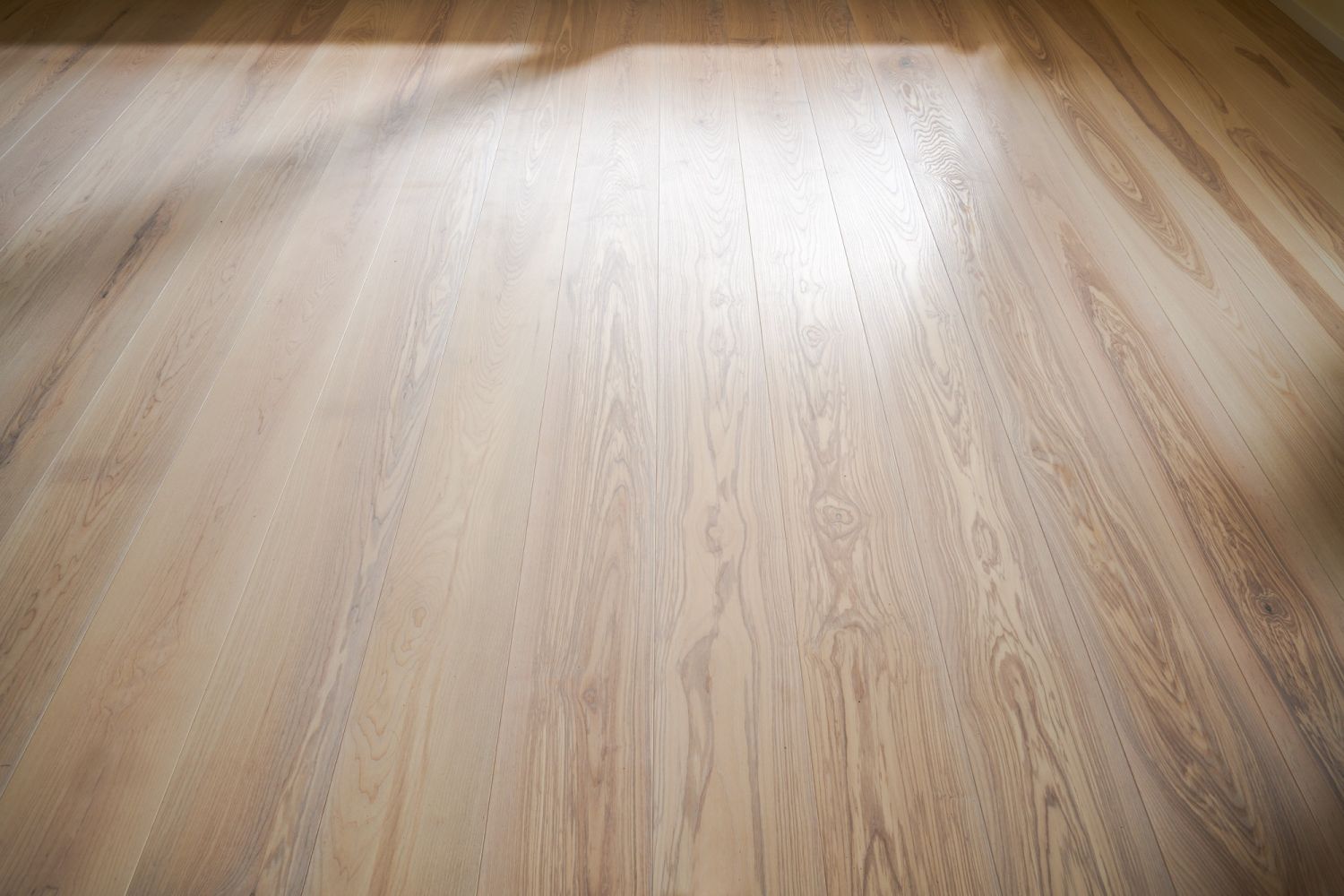 Ash wood floor with visible grain and light reflections
