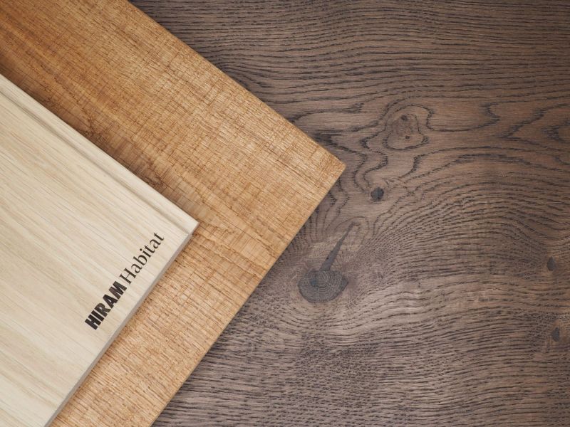 Light and dark oak plank floors with varied, natural grain patterns, featuring the inscription “HIRAM Habitat” that highlights the uniqueness and quality of the material.