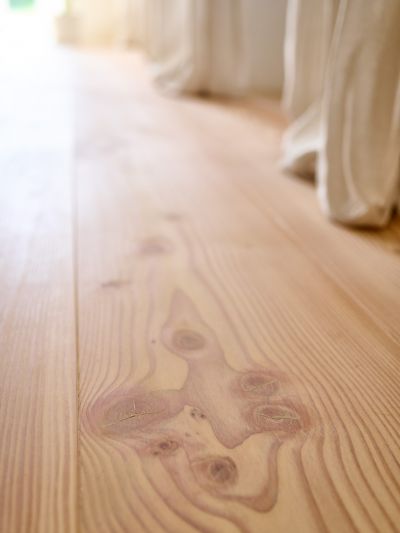 Nahaufnahme eines Douglasie Dielenboden; sichtbaren Maserungen; Hintergrund helle Vorhänge