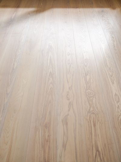 Ash wood floor with visible grain and light reflections