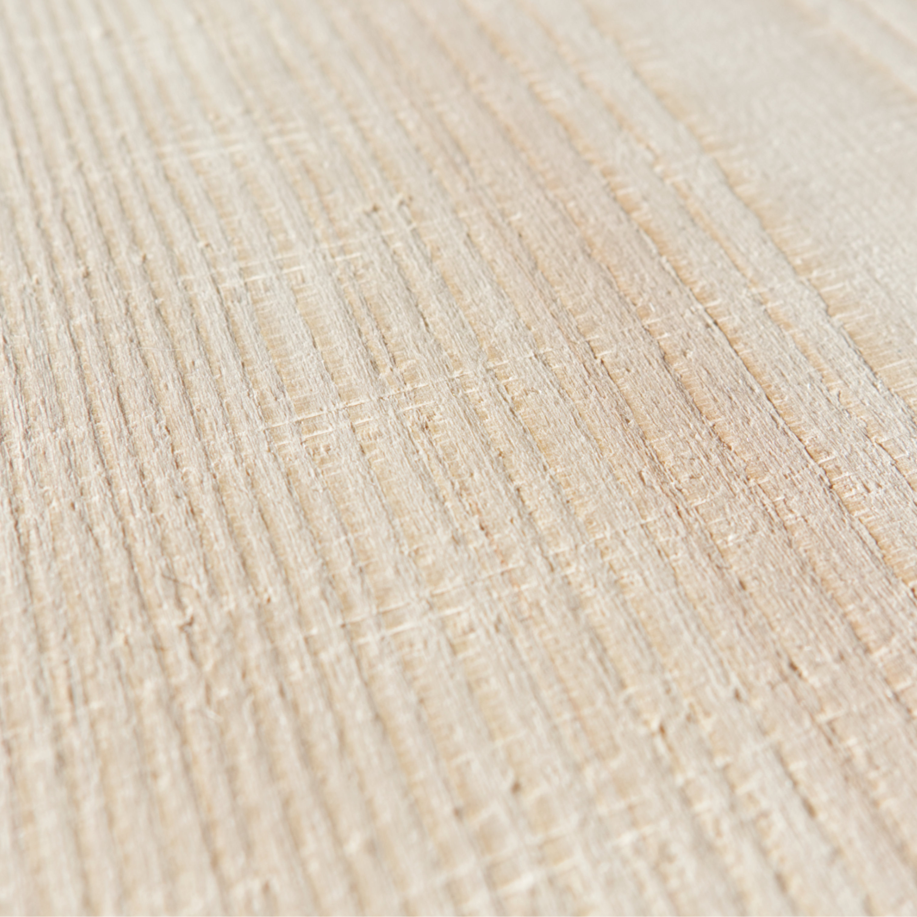 Nahaufnahme eines Weißtanne Dielenbodens mit sägerauer Optik. Auf dem Holz verlaufen die Spuren der Bandsäge als Striche horizontal und vertikal zueinander. So ist ein kariertes Oberflächenmuster zu sehen.